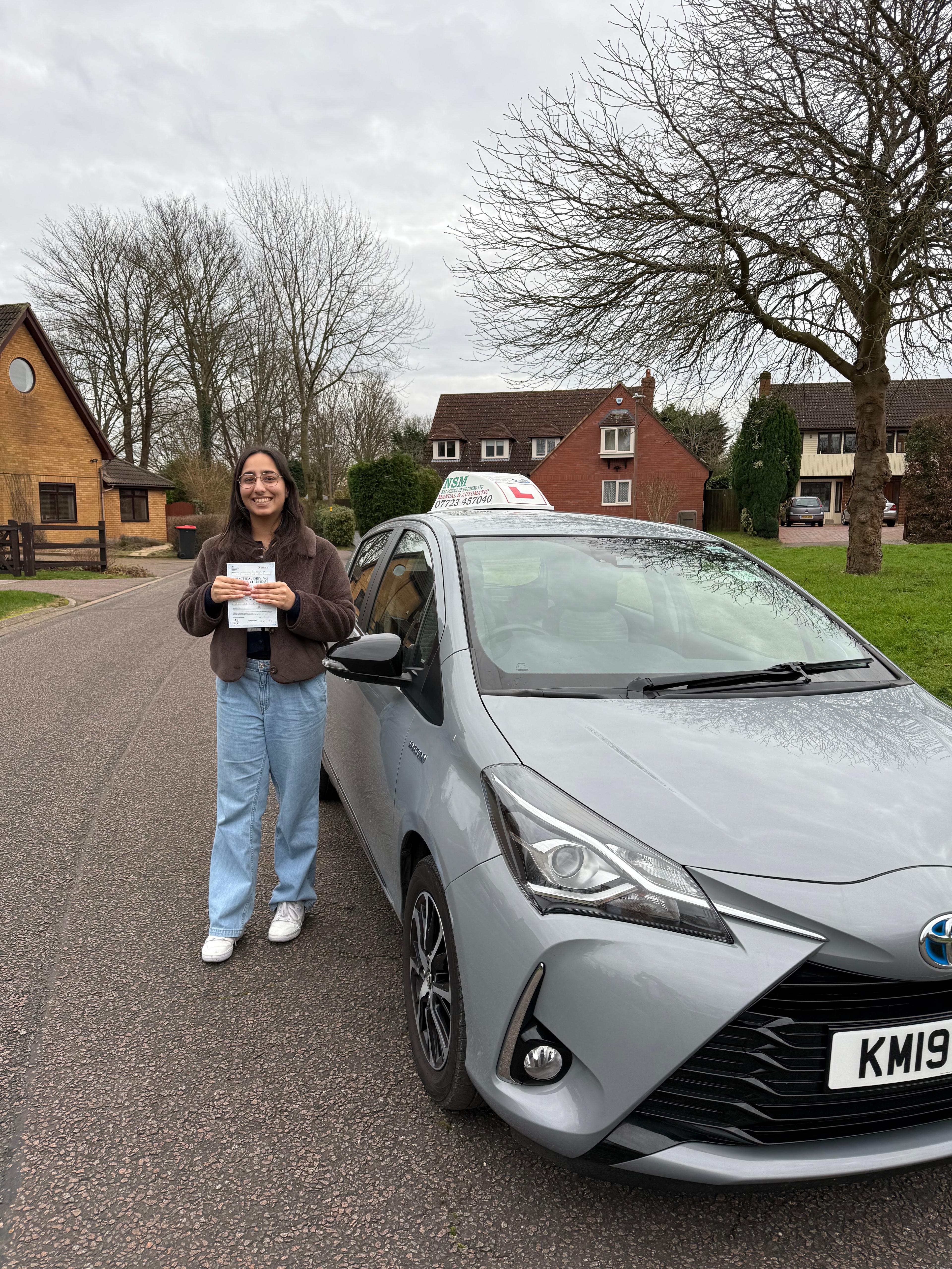 Driving instructor assisting learner driver